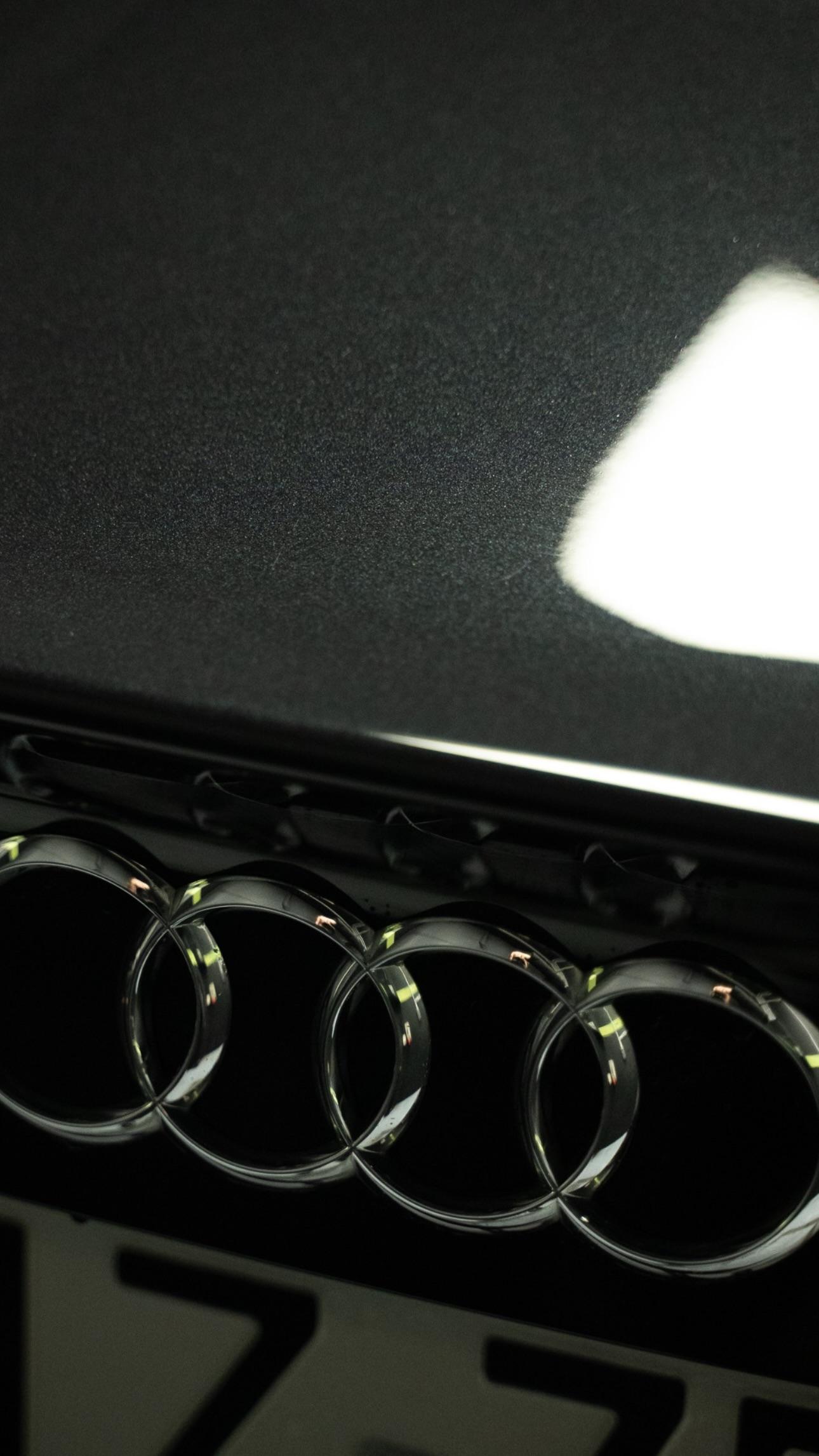 Emblemat Audi na ciemnym lakierze po myciu